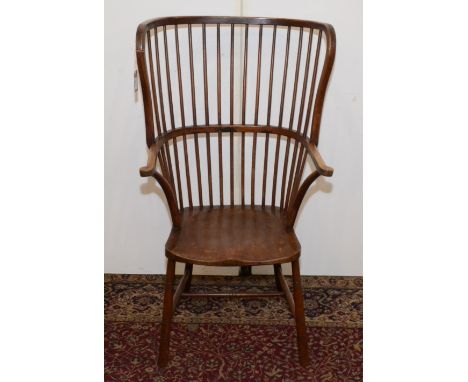 A large Windsor type armchair, late 19th century, with a stick filled back, solid arms and seat and on ring turned legs joine