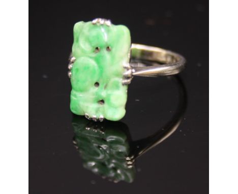 A 9ct white gold ring set a panel of carved jade.