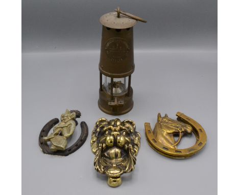A brass miner's lamp by The Protector Lamp and Lighting Company Ltd of Eccles, Type 6, height 25cm, a brass lion's mask door 