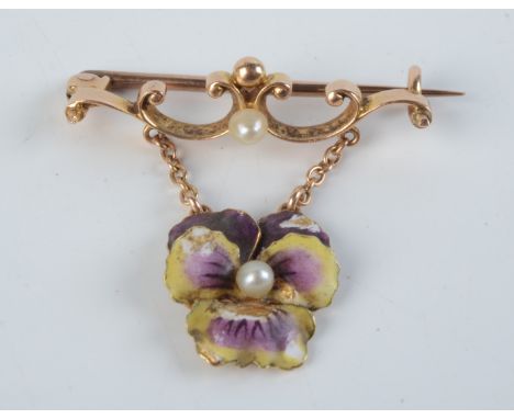 A late Victorian gold and enamel bar brooch, from it hangs a coloured enamel pansy with a pearl at the centre.