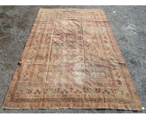 A Kerman carpet, South West Persia, with medallions, flowering vines, plants and boteh, within an ivory floral border, 419 x 