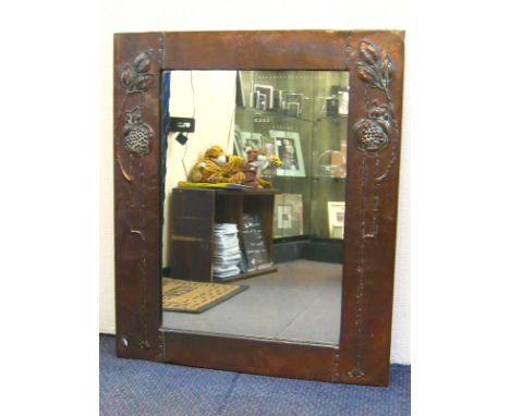 A copper framed Art Nouveau mirror embossed with stylised leaf and pomegranate forms after Charles Rennie Mackintosh, circa 1