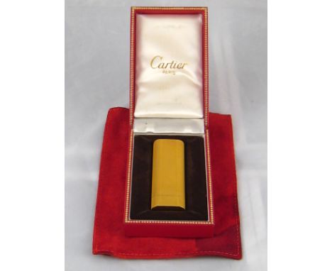 Cartier. A gold plated cigarette lighter by Cartier Paris, numbered 99628 S, approx 7cm, in Cartier box with pouch (box and p