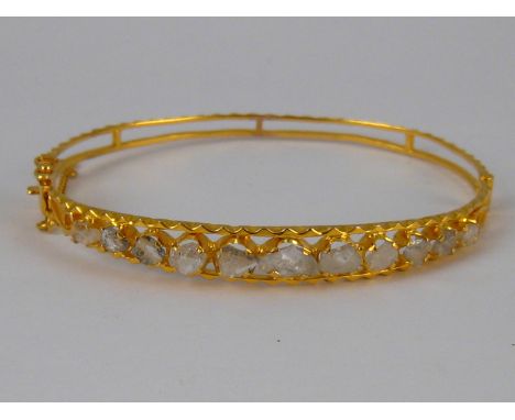 A yellow metal (tests 18 carat gold) rose cut diamond bangle, internal width approx 5.5cm, 8 gms
