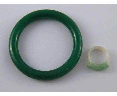A mixed lot comprising a carved jade ring (size R) and a green hardstone bangle.