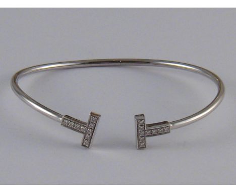 Tiffany & Co. An 18 carat white gold diamond Tiffany T bangle by Tiffany & co, accompanied by original purchase receipt for £