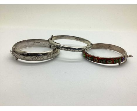 A Hallmarked Silver Hinged Bangle, of etched scrolling design, together with a hallmarked silver bangle of the same design, a
