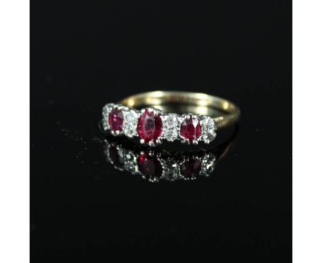 A three stone ruby ring interspaced with diamonds, ring size N 1/2