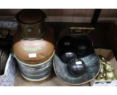 A 19th Century brass coal helmet containing four lawn bowls plus a copper ships masthead lamp (glass as found)