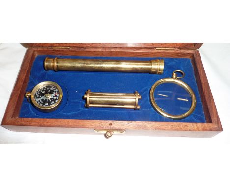 Small display case with brass egg timer, small glass telescope, magnifying glass and compass