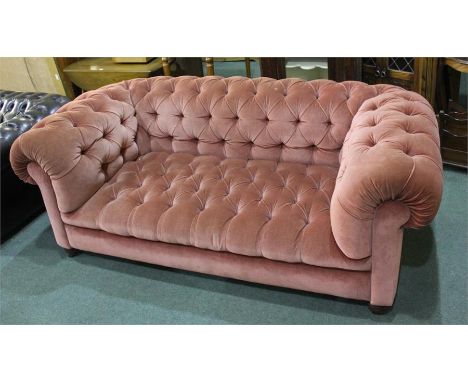 Chesterfield sofa, with button back arms and seat raised on turned feet