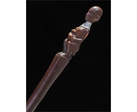 Walking stick with a carved African figure sitting on a stool holding a child. The woman with white metal collar. 109cm 