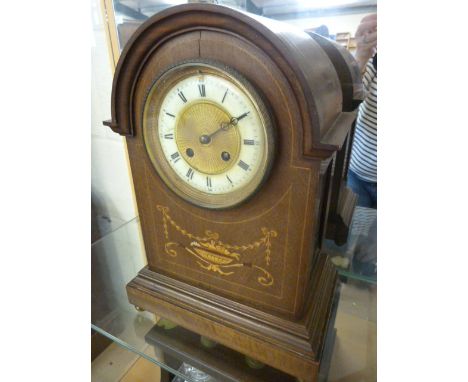 Mahogany mantle clock inlaid with floral decoration. Roman numeral chapters on an enamelled and gilt face stamped inside Marq