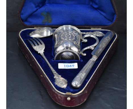 A Victorian cased silver christening set, comprising mug, spoon, fork and silver handled (metal core) and silver bladed knife