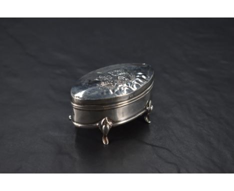 An Edwardian silver ring box, of hinged elliptical form, the cover embossed with cherubs and opening to reveal the internal s