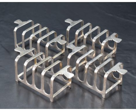 A group of four Art Deco design silver four division toast racks, each of rectangular form with stylised handles, marks for S