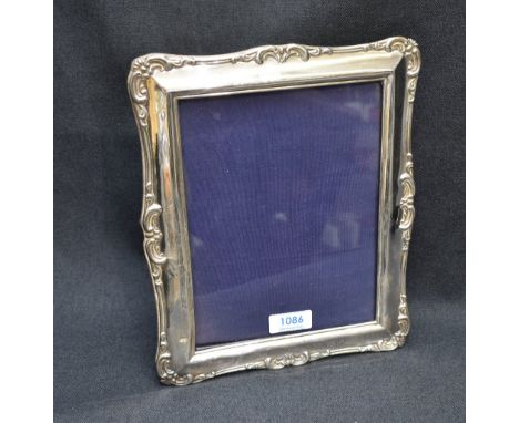 A large early 20th century silver mounted photograph frame, of rectangular form with embossed scrolling decoration, marks for