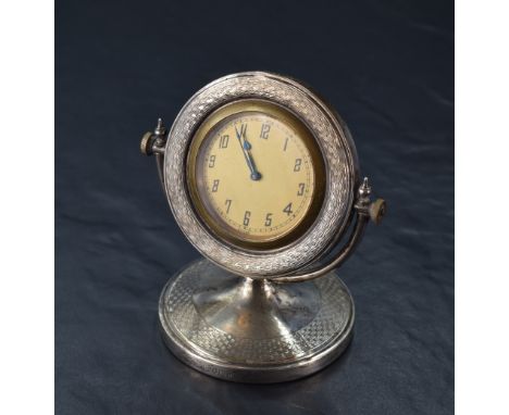 A George V silver desk clock, the circular dial with Arabic hours and marked 'Swiss' within an engine-turned surround and piv