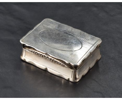 A George III silver snuff box, of hinged rectangular form, the cover with shaped outline and foliate moulded lip, enclosing e