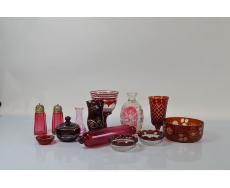 A collection of cranberry glass, including a rolling pin, 29cm, two sugar sifters, a cut glass Bohemian dressing table jar an