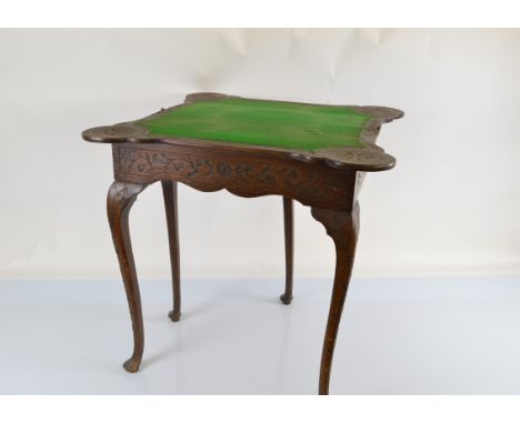 An early 20th Century Queen Anne style carved oak card table, with gate leg mechanism, fold over top and green baize playing 