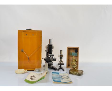 A mid 20th Century lacquered steel and cast iron Chinese microscope, model L-201 in wooden case, with three rotating lenses, 