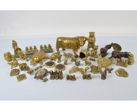 A collection of brass animal figures, including a heavy cast model of a horned cow, bear money box, various tortoises, owls, 