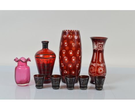 A Bohemian cranberry glass liquor set, comprising decanter and five conical beakers with silvered decoration of a large churc