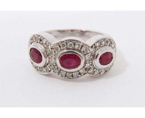 White gold 9ct synthetic ruby and diamond ring with three oval mixed cut synthetic rubies surrounded by a border of diamonds 