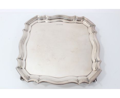 George V silver salver of shaped square form with stepped borders on four leaf scroll feet. (Sheffield 1913) R F Mosley &amp;