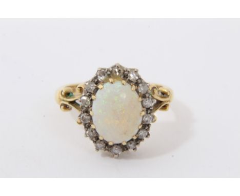 Gold 18ct opal and diamond cluster ring with an oval opal cabochon surrounded by 14 single cut diamonds in claw setting with 