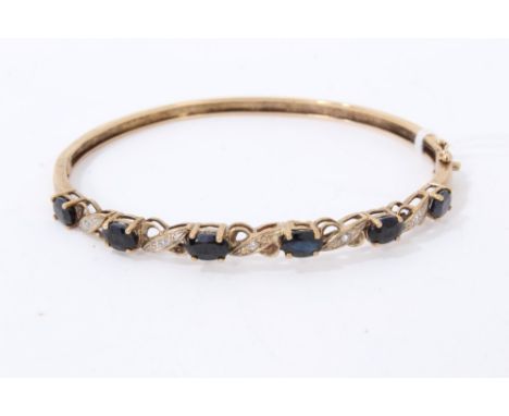 Gold 9ct sapphire and diamond bangle set with six oval cut sapphire interspaced with diamonds in illusion settingCondition re