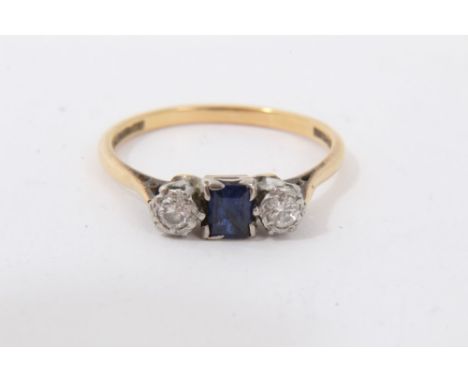 Gold 18ct sapphire and diamond three stone ring with a central emerald cut blue sapphire flanked by a brilliant cut diamond t