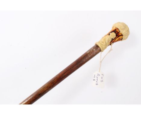 Early 20th century Hickory walking stick, with moulded earthenware handle in the form of a classical child sitting under a tr