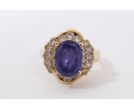 Gold 14ct blue topaz and diamond cluster ring with a central oval blue topaz surrounded by a border of brilliant cut diamonds