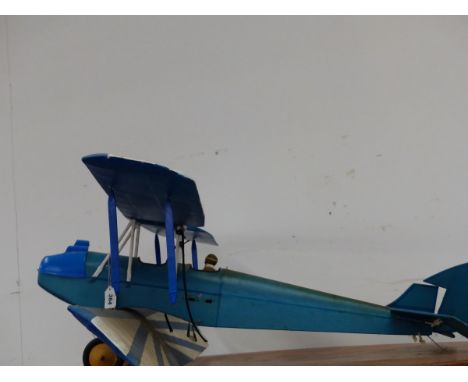 A SCALE MODEL BIPLANE ONCE POWERED BY A LIVE FUEL SINGLE PROP ENGINE.