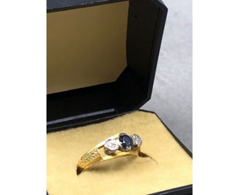 AN 18ct STAMPED SAPPHIRE AND DIAMOND THREE STONE RING. FINGER SIZE K 1/2. WEIGHT 3.4grms. 