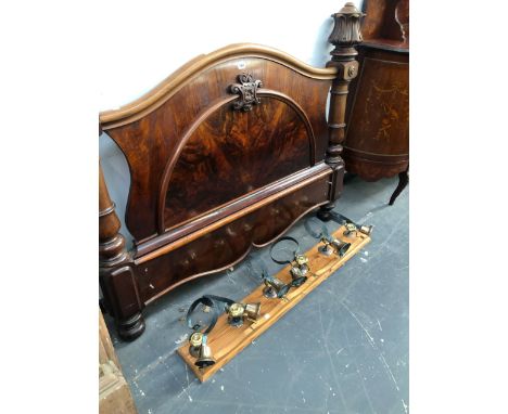 A GROUP OF SIX ANTIQUE SERVANTS BELLS, TOGETHER WITH A FLAME MAHOGANY HEADBOARD. 