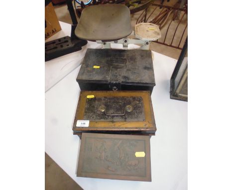 An old set of kitchen scales with copper pan; two money boxes; and an ornate biscuit tin 