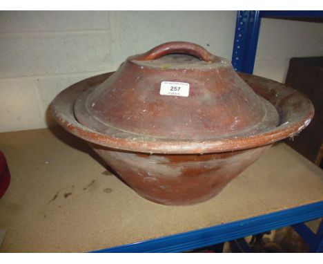 A large earthen ware basin with lid