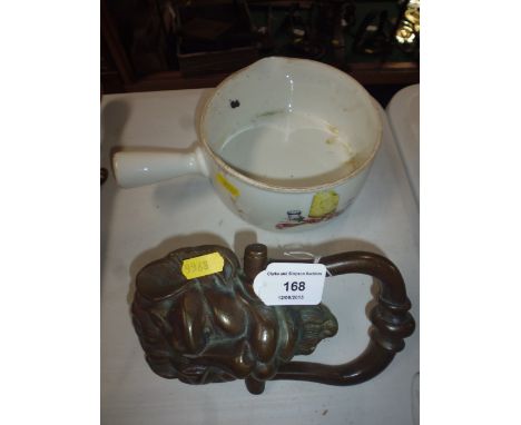 A brass lion head door knocker; and a French porcelain saucepan 