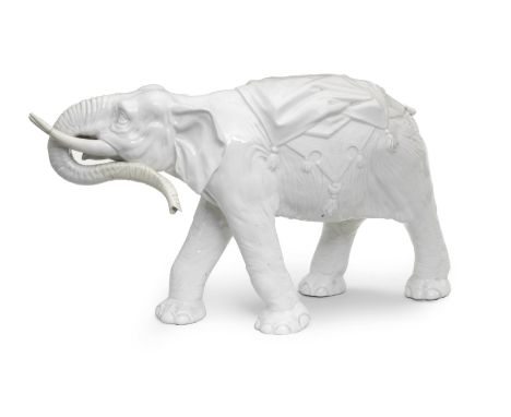 A very large 19th century Continental white porcelain model of an elephantnaturalistically modelled with a tasselled cushion 