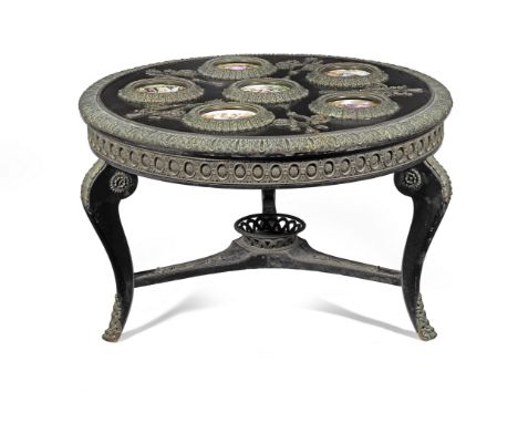 A French early 20th century ebony and ebonised low table inset with four contemporary enamels and two contemporary porcelain 