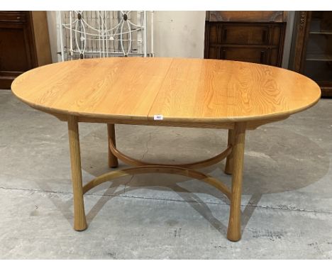 Ercol Furniture. A model 926 elm dining table, extending to 84' with concealed folding extra leaf