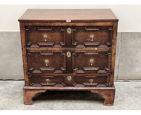 A 17th century and later joined oak and walnut chest with three geometrically moulded drawers on later bracket feet. The side