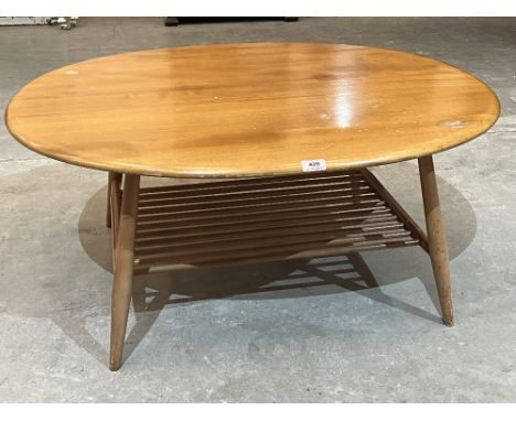 Ercol Furniture. A blonde elm oval low table with laddered undertier. 38½' long. Some water damage and dents to top. c.1970