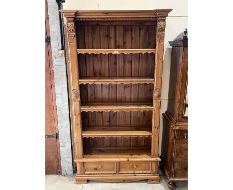 A pine open bookcase with four shelves over a pair of base drawers on bracket feet. 40' w x 79'h
