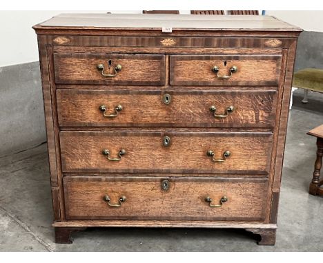 A George III oak and mahogany crossbanded chest of drawers on bracket feet. 43' wide