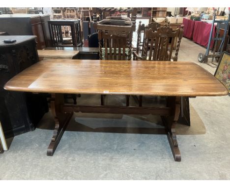 An Ercol refectory style dining table on shaped trestle supports. 71' long
