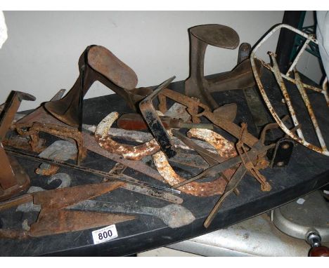 A shelf of metal items including shoe lasts. 